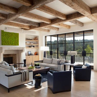 This is an example of a mediterranean formal open plan living room in San Francisco with white walls, light hardwood flooring, a standard fireplace, a stone fireplace surround and beige floors.