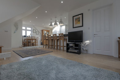 Medium sized modern enclosed living room in Hertfordshire with white walls, light hardwood flooring and no tv.