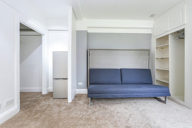 Living room - small contemporary open concept carpeted and beige floor living room idea in London with white walls and no fireplace