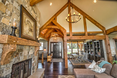 Inspiration for a large rustic open concept and formal dark wood floor and brown floor living room remodel in Portland with beige walls, a standard fireplace, a stone fireplace and no tv