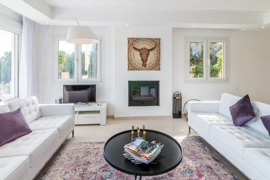 マラガにあるコンテンポラリースタイルのおしゃれなLDK (白い壁、薪ストーブ、漆喰の暖炉まわり、ベージュの床) の写真