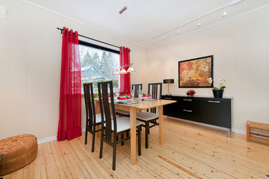Foto de salón cerrado contemporáneo de tamaño medio con paredes beige, suelo de madera clara, estufa de leña, marco de chimenea de hormigón y televisor colgado en la pared