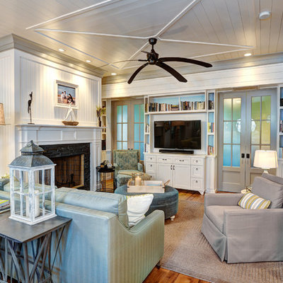 Inspiration for a mid-sized coastal open concept medium tone wood floor living room remodel in Charleston with white walls, a standard fireplace, a stone fireplace and a tv stand