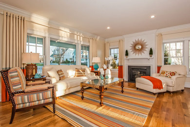 Example of a mid-sized eclectic formal and open concept medium tone wood floor living room design in Boston with beige walls, a standard fireplace, a wood fireplace surround and no tv