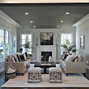 Example of a large transitional formal and enclosed dark wood floor living room design in New York with gray walls, a standard fireplace, a stone fireplace and no tv