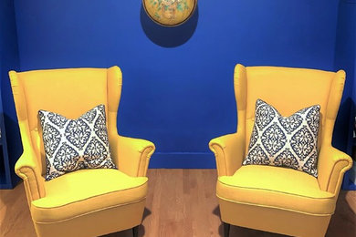 シアトルにあるお手頃価格の中くらいな地中海スタイルのおしゃれなリビング (青い壁、淡色無垢フローリング、標準型暖炉、レンガの暖炉まわり、テレビなし、オレンジの床) の写真