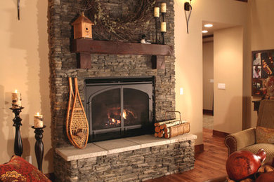 Imagen de salón abierto rústico de tamaño medio con suelo de madera en tonos medios, todas las chimeneas y marco de chimenea de piedra