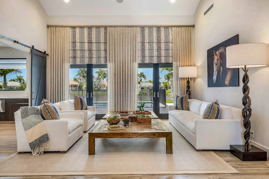 Beach style medium tone wood floor and brown floor living room photo in Miami with gray walls