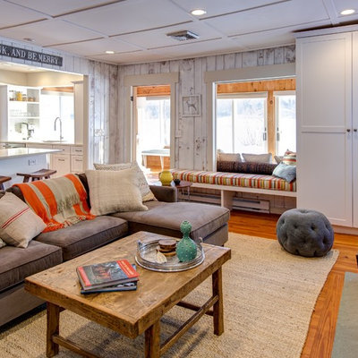 Example of a beach style formal and open concept medium tone wood floor living room design in Boston with a standard fireplace and a stone fireplace