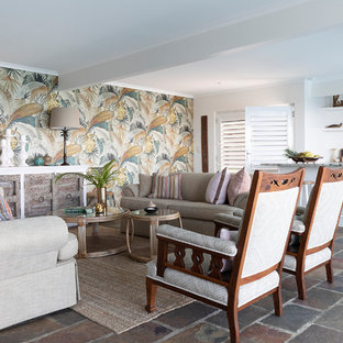 This is an example of a tropical open concept living room in Brisbane with beige walls and grey floor.