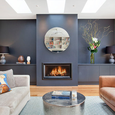 Trendy open concept medium tone wood floor and brown floor living room photo in Sydney with blue walls, a ribbon fireplace and no tv