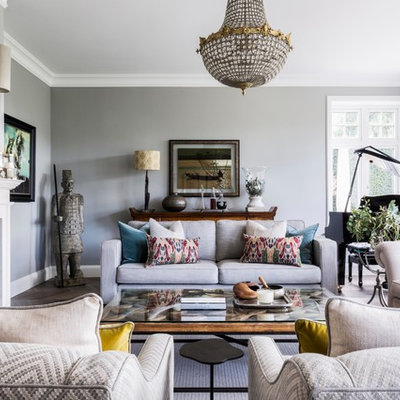 Example of a large transitional enclosed brown floor living room design in Surrey with a music area, gray walls, a standard fireplace and a metal fireplace