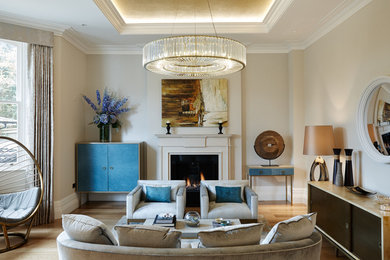 Esempio di un soggiorno classico con pareti beige, parquet chiaro, camino classico e nessuna TV