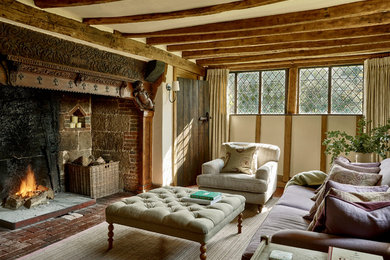 Foto de salón de estilo de casa de campo de tamaño medio con paredes blancas, todas las chimeneas, suelo de ladrillo y suelo marrón