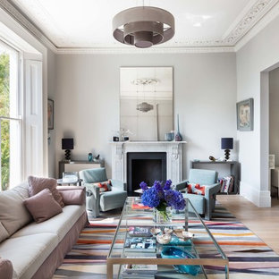 Large scandi formal enclosed living room in London with a standard fireplace, grey walls, light hardwood flooring and no tv.