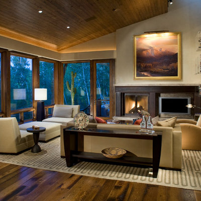 Inspiration for a mid-sized contemporary formal and enclosed medium tone wood floor and brown floor living room remodel in Denver with a standard fireplace, a wall-mounted tv, beige walls and a metal fireplace