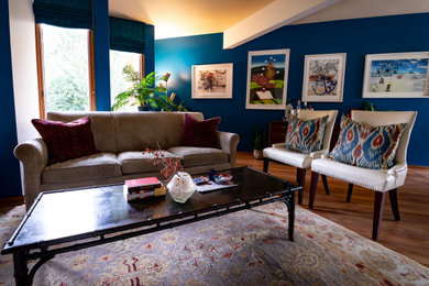 他の地域にあるお手頃価格の中くらいなコンテンポラリースタイルのおしゃれなLDK (青い壁、ラミネートの床、暖炉なし、壁掛け型テレビ、茶色い床) の写真