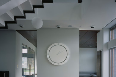 Ejemplo de salón abierto vintage de tamaño medio con paredes blancas, suelo de cemento, chimenea de doble cara y suelo gris