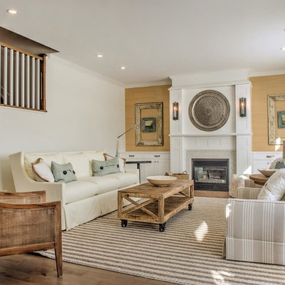Large country open concept medium tone wood floor living room photo in Ottawa with white walls, a standard fireplace, a wood fireplace surround and no tv