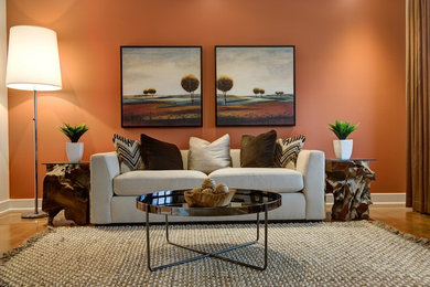 オタワにある広いトランジショナルスタイルのおしゃれなリビング (オレンジの壁、淡色無垢フローリング、暖炉なし、テレビなし) の写真