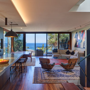 Inspiration for a tropical open concept living room in Sydney with blue walls, dark hardwood floors and brown floor.