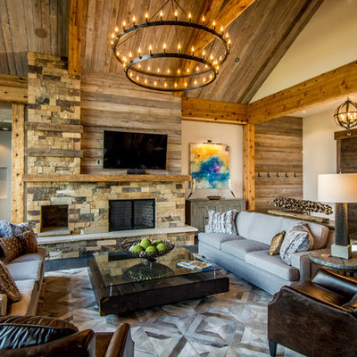 Example of a large mountain style open concept and formal medium tone wood floor living room design in Albuquerque with beige walls, a stone fireplace, a wall-mounted tv and a standard fireplace