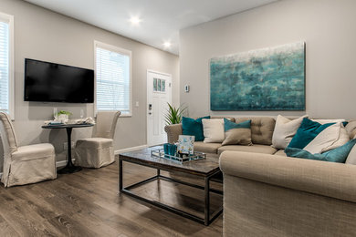 Foto di un piccolo soggiorno classico chiuso con pareti beige, pavimento in laminato, TV a parete e pavimento marrone