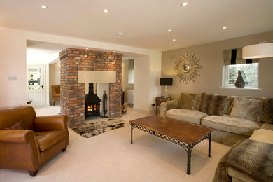 Immagine di un grande soggiorno minimalista aperto con sala formale, pareti bianche, moquette, stufa a legna, cornice del camino in mattoni e TV a parete