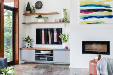 メルボルンにある高級な広いミッドセンチュリースタイルのおしゃれなLDK (白い壁、スレートの床、薪ストーブ、漆喰の暖炉まわり、壁掛け型テレビ、茶色い床) の写真