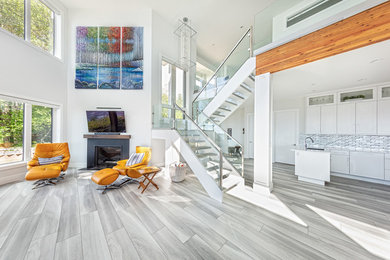 Example of a large trendy open concept vinyl floor and gray floor living room design in Edmonton with white walls, a standard fireplace, a metal fireplace and a wall-mounted tv