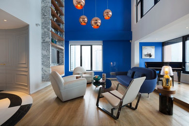 Idée de décoration pour un salon design avec une salle de musique, un mur bleu et un téléviseur fixé au mur.