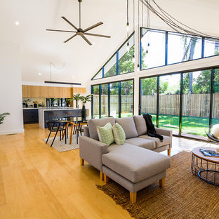 Photo of a large contemporary open concept living room in Brisbane with white walls, light hardwood floors and brown floor.