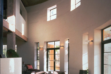 Ejemplo de salón cerrado contemporáneo de tamaño medio sin chimenea con paredes blancas, suelo de cemento, suelo gris y vigas vistas