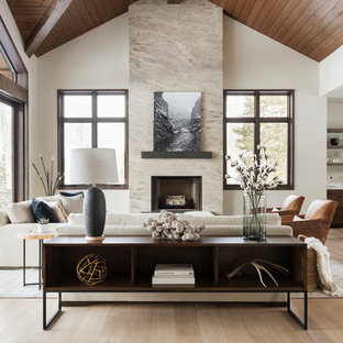 Imagen de salón con barra de bar abierto, contemporáneo, grande, sin televisor, con paredes beige, suelo de madera en tonos medios, chimenea tradicional, marco de chimenea de piedra y suelo beige