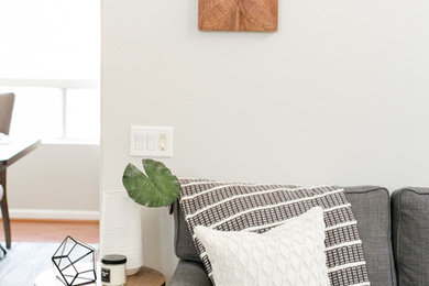 Mittelgroßes, Fernseherloses, Offenes, Repräsentatives Skandinavisches Wohnzimmer mit grauer Wandfarbe, braunem Holzboden und braunem Boden in Los Angeles