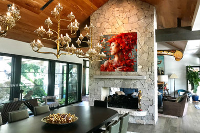 Photo of a large traditional living room in Austin with white walls, medium hardwood flooring, a two-sided fireplace, a stone fireplace surround, grey floors and a vaulted ceiling.