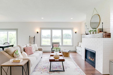 Mid-sized transitional open concept and formal brown floor and medium tone wood floor living room photo in Minneapolis with white walls, a standard fireplace, a brick fireplace and no tv