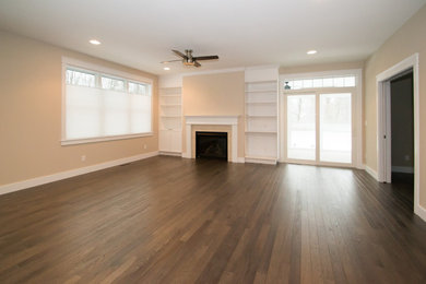 Example of an arts and crafts open concept light wood floor and brown floor living room design in Boston with beige walls, a standard fireplace, a tile fireplace and a media wall