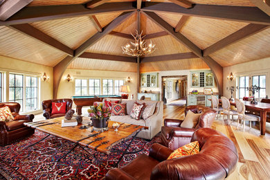 Foto de salón abierto rural con paredes beige, suelo de madera clara y billar