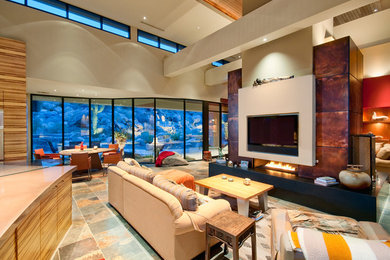 Inspiration for a large southwestern open concept porcelain tile living room remodel in Phoenix with a two-sided fireplace and a wall-mounted tv