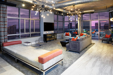 Diseño de salón abierto moderno grande sin chimenea con paredes grises, suelo de baldosas de cerámica y televisor colgado en la pared
