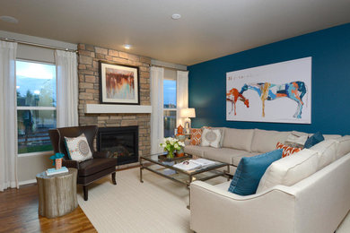 デンバーにある広いトランジショナルスタイルのおしゃれなリビング (青い壁、無垢フローリング、標準型暖炉、石材の暖炉まわり) の写真