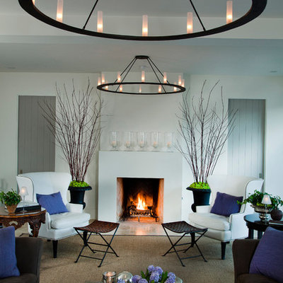 Example of a large transitional enclosed carpeted and brown floor living room design in San Diego with white walls, a standard fireplace, no tv and a plaster fireplace