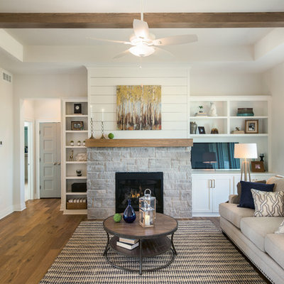 Mid-sized farmhouse open concept medium tone wood floor living room photo in Wichita with white walls, a standard fireplace and a stone fireplace
