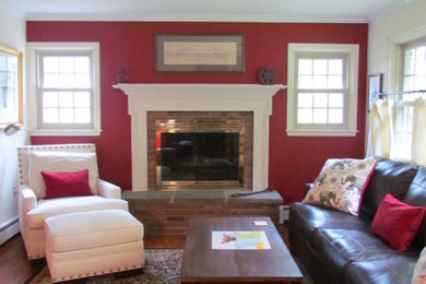 フィラデルフィアにある高級な中くらいなトラディショナルスタイルのおしゃれなリビング (赤い壁、濃色無垢フローリング、標準型暖炉、レンガの暖炉まわり、テレビなし、茶色い床) の写真