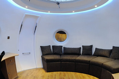 Ejemplo de salón tipo loft actual de tamaño medio con paredes blancas y suelo de madera clara