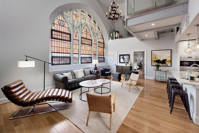 Diseño de salón abierto clásico con paredes grises, suelo de madera clara y suelo beige