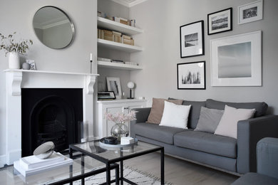 This is an example of a small scandi enclosed living room in Hampshire with grey walls, light hardwood flooring and white floors.