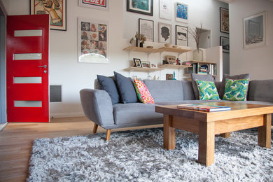 Foto di un grande soggiorno minimal aperto con pareti bianche, parquet chiaro e TV autoportante