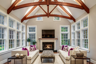 Inspiration for a large transitional open concept brown floor and dark wood floor living room remodel in Boston with beige walls, a standard fireplace, a wood fireplace surround and a wall-mounted tv